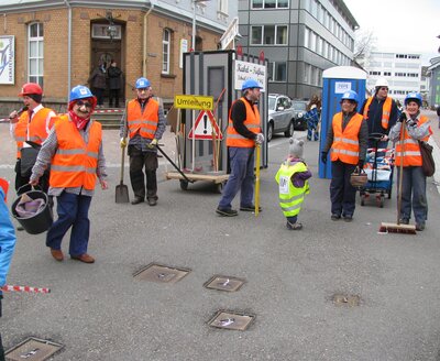 Trupp der „Kabel-Tiefbau SHO“ mit Klohäuschen und Baucontainer