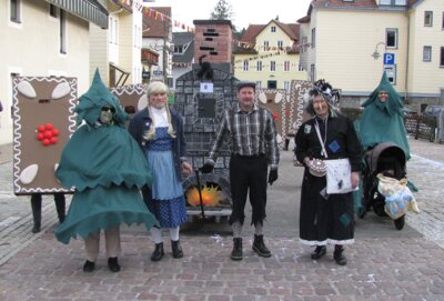 Gruppenbild mit kostümierten Narren als Hänsel und Gretel mit Ofen, der bösen Hexe, Bäumen und den Lebkuchen